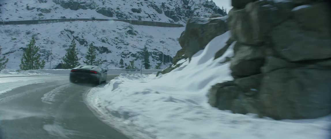 Sports car speeding along a winding road on a winter day