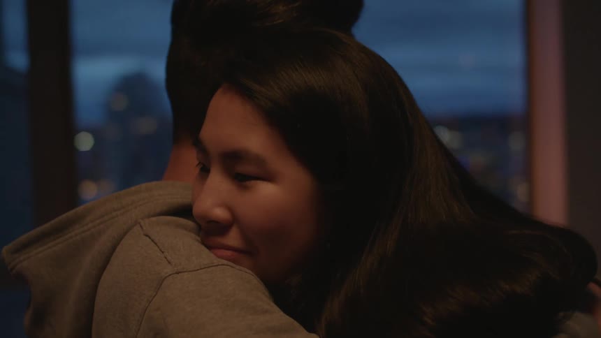 A man and woman hugging in a room
