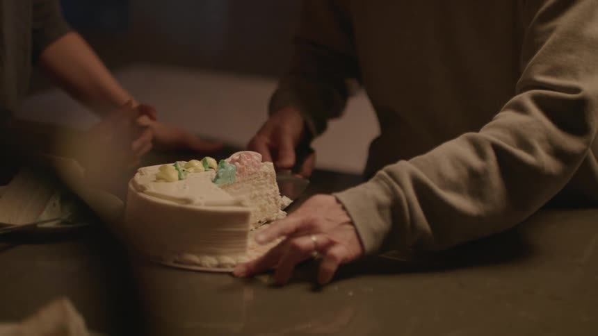 A family is celebrating a childs birthday at home with a birthday cake