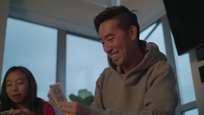 Happy family playing cards on the living room at home