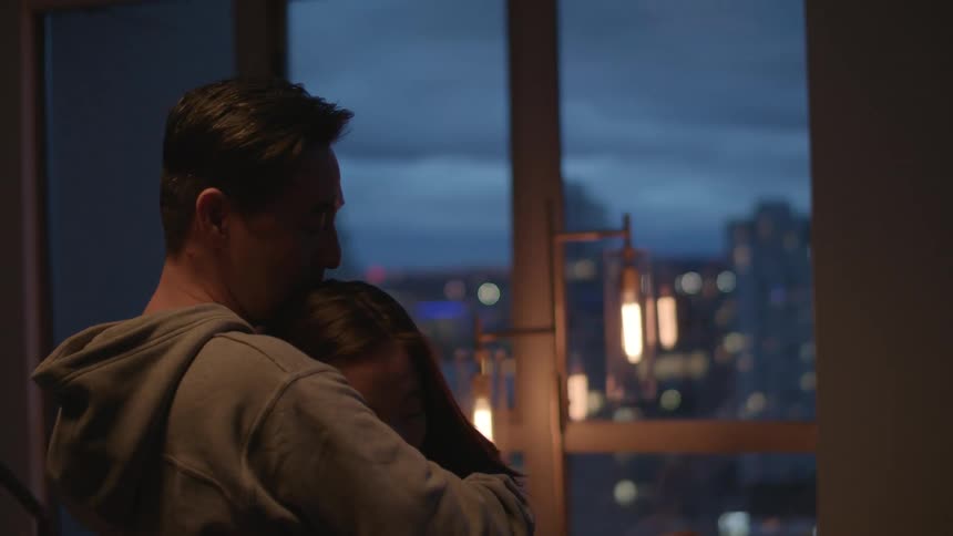 Two people are dancing and the female pulls back to smile then the man kisses her forehead