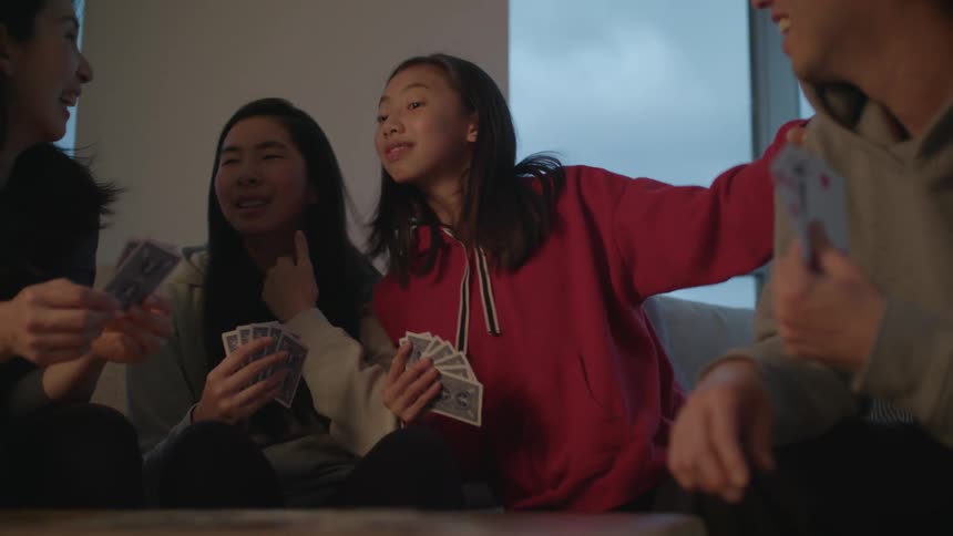 Happy family playing cards on the living room at home