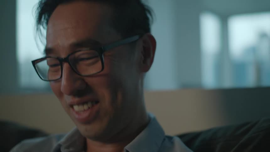 A man is laughing and smiling indoors