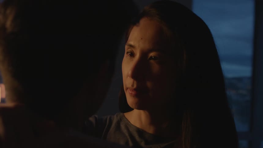 Young couple talk while dancing on a dimly lit living room in an apartment at evening