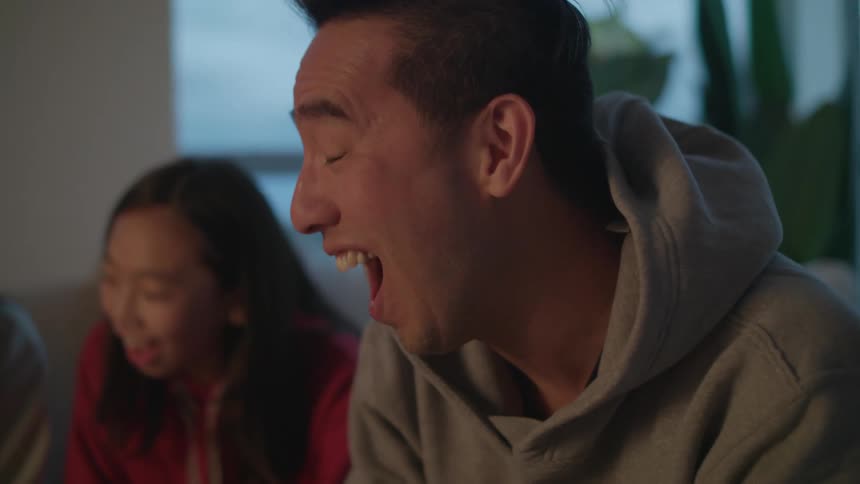 People are laughing and enjoying themselves as they sit on a couch