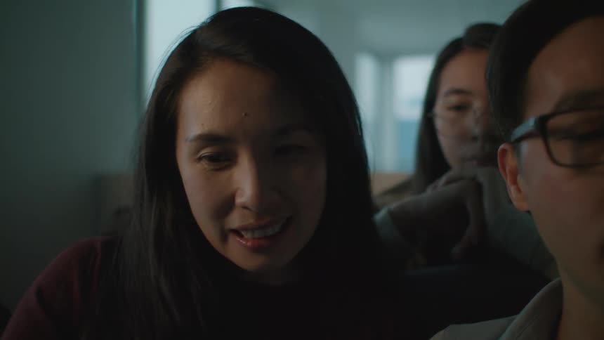 A group of asian people are sitting in a room chatting
