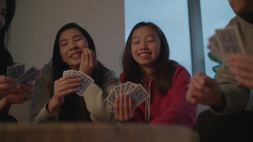Happy family playing cards on the living room at home