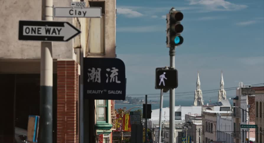 A pedestrian crosswalk signal counts down to zero at a downtown intersection of a small coastal town during the day