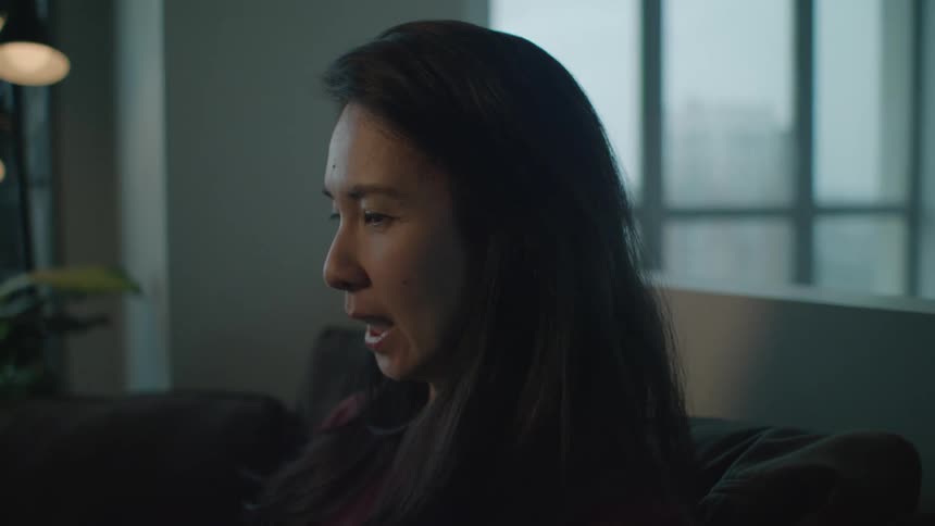 A woman is sitting on the couch talking