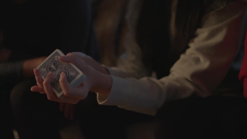 Women sit down and shuffle cards