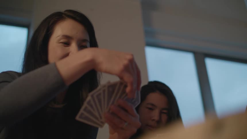 Family playing cards on the living room at home
