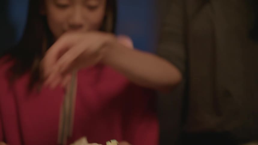 A man cuts a cake and laughs as his daughter watches