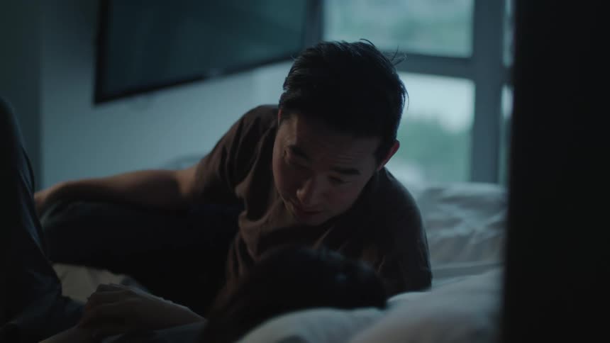 Couple talking while laying in bed in the bedroom at home