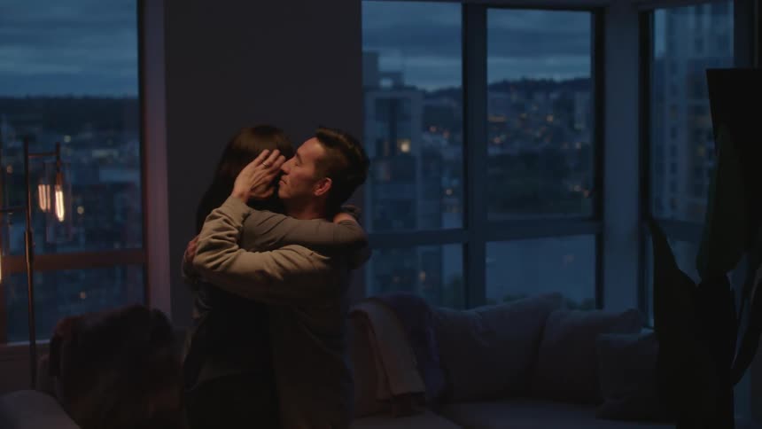 A couple are dancing in their living room