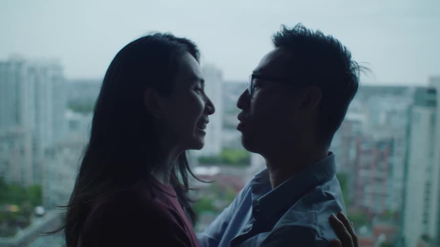 Husband and wife are kissing in a downtown city