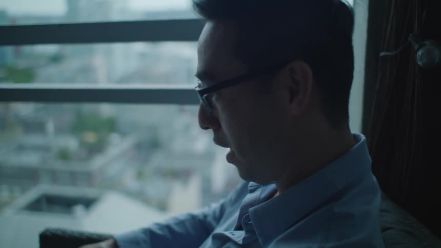 Man sitting near a window talking on a video call