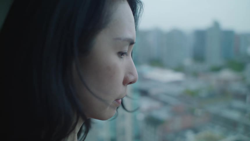 Young woman looking out the window at the city skyline