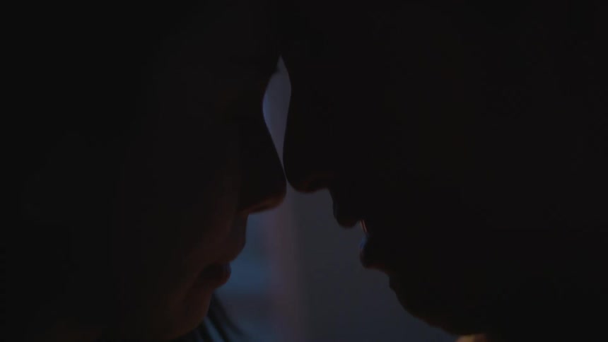 Husband with grey hoodie and woman with straight hair dance head to head in dim lit room