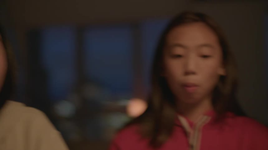 Family sitting at the table at home eating cake at night