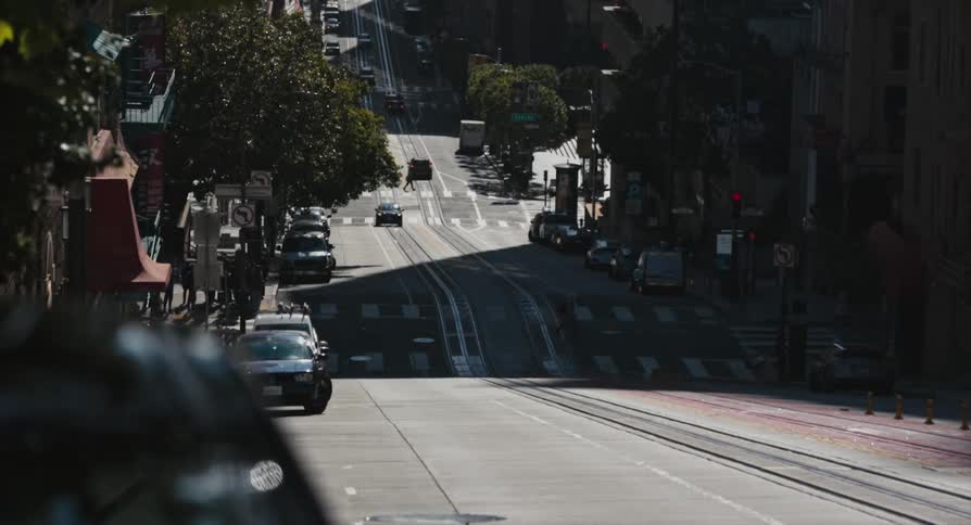 A road on hills with vehicles trees and people