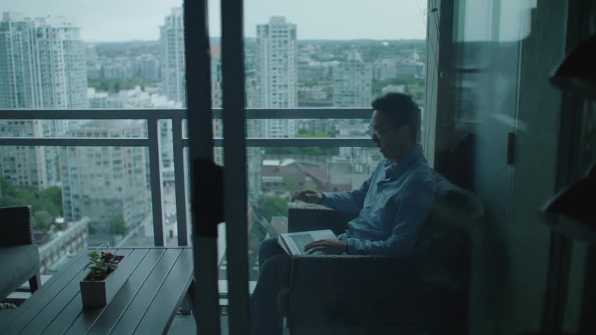 A man sitting in a building with a laptop
