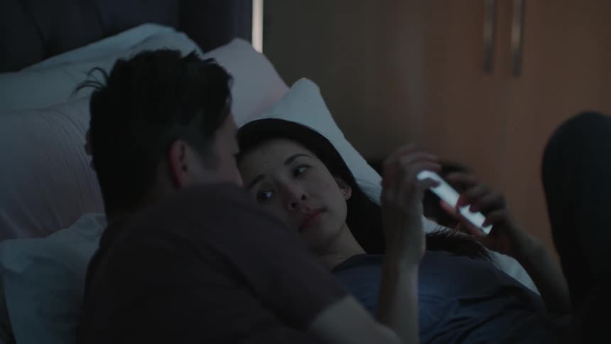 Young couple resting in bed turn around and hug each other