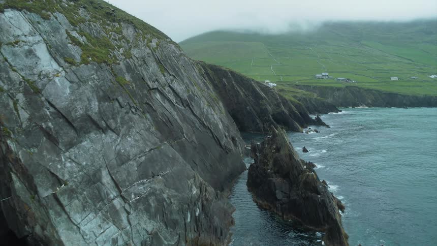 The crashing ocean meets sheer rocky cliffs