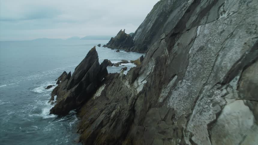 Waves crashing into the sheer rocky Irish coastline