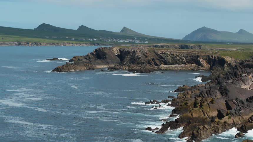 Waves crash against a steep and rocky coast