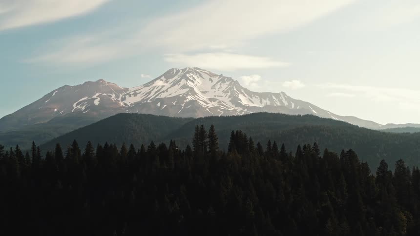Snow cover the peak of a mountain range near the pine tree forest in the morning