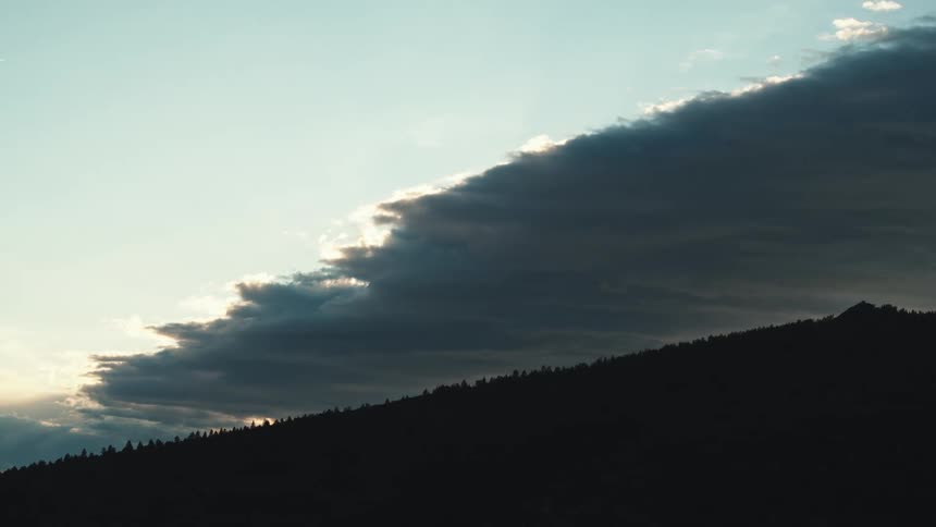 Mountain under the shadow of large high clouds at evening