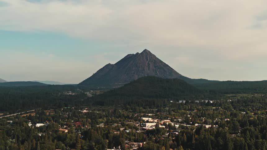 Aerial view of a small town surrounded by pine trees near the mountain peak
