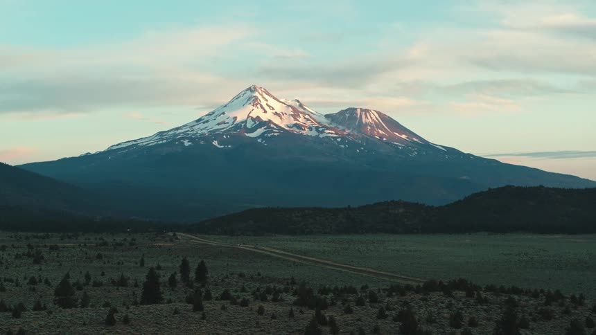 A view of a landscape with a mountain in the distance