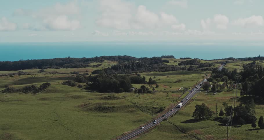 Steady traffic on a country highway under a cloudy sky
