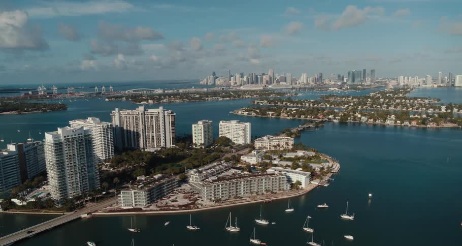 Boats dot on of series of islands connected by bridges with city in background