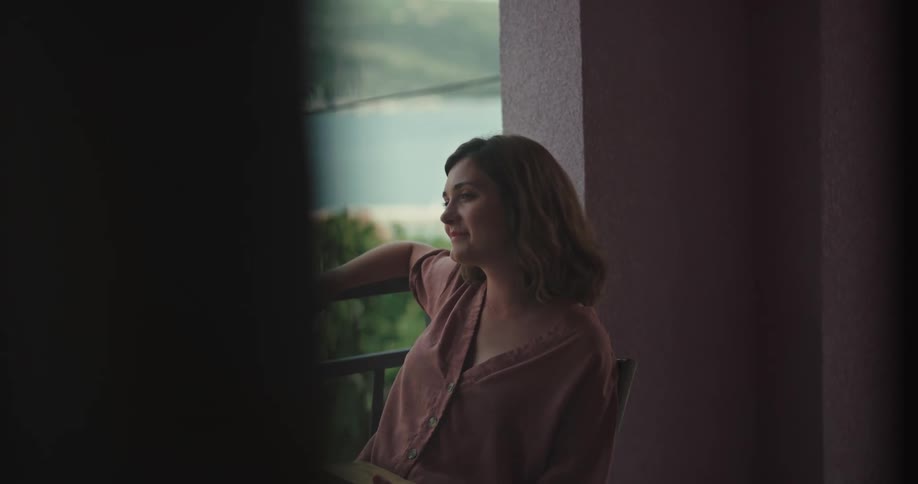 A woman is sitting on a balcony outdoors in spring