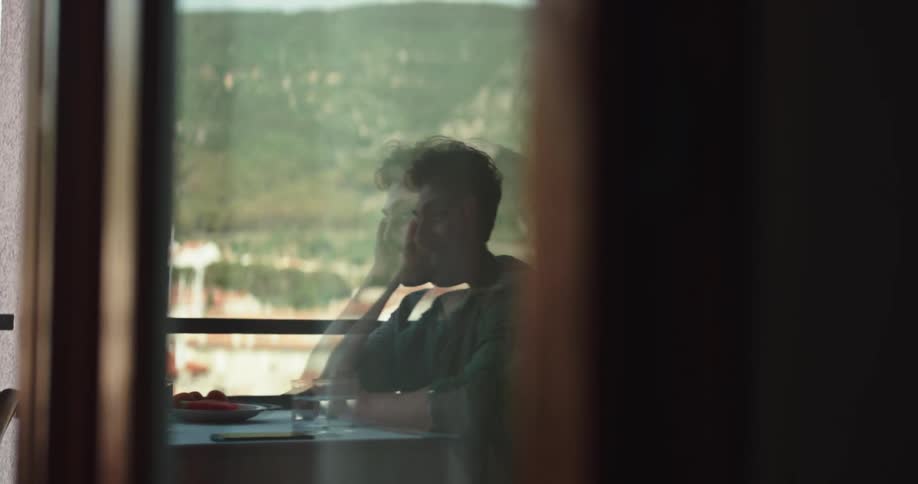 A man is talking as he sits at a table in a restaurant