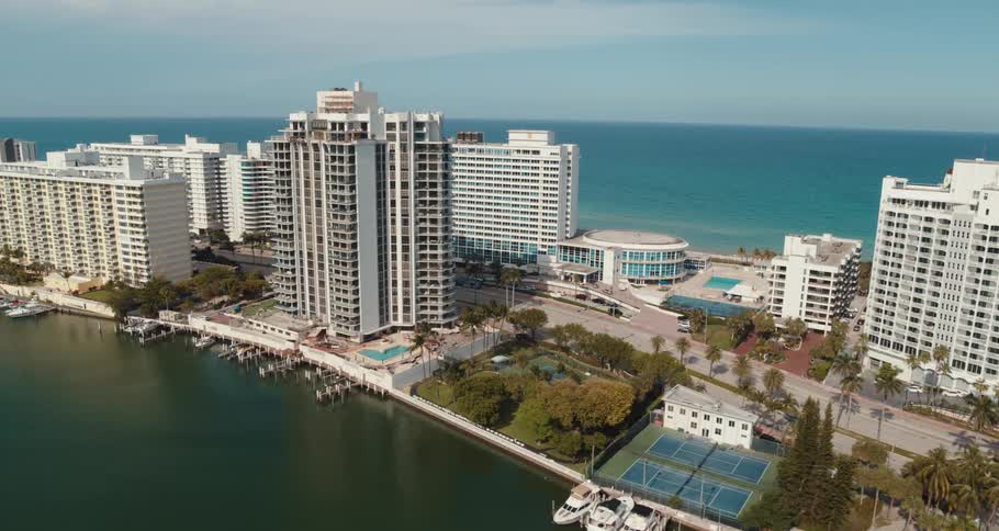 An aerial view of a manmade island filled with hotels with the ocean and horizon in the background