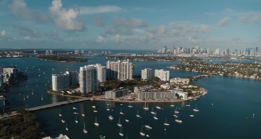 An island sits in the middle of a river in a city and has many buildings on it