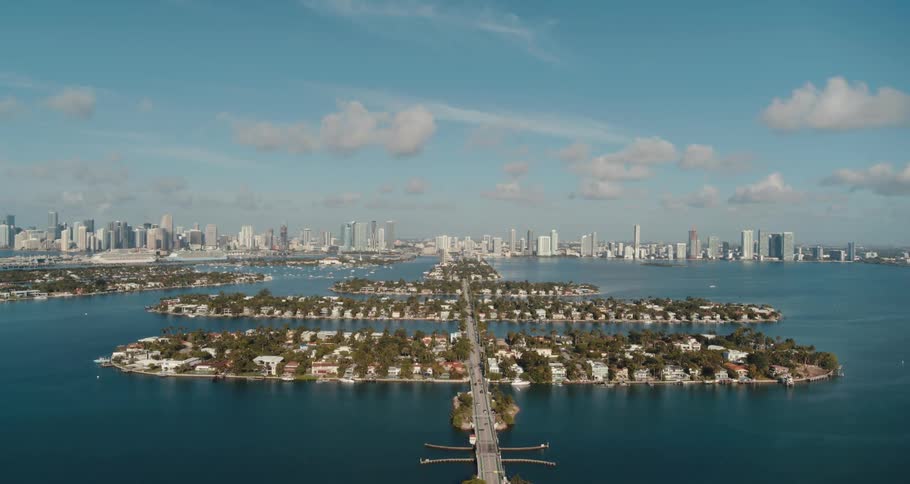 An aerial view of a huge metropolis with manmade islands on a partly cloudy day