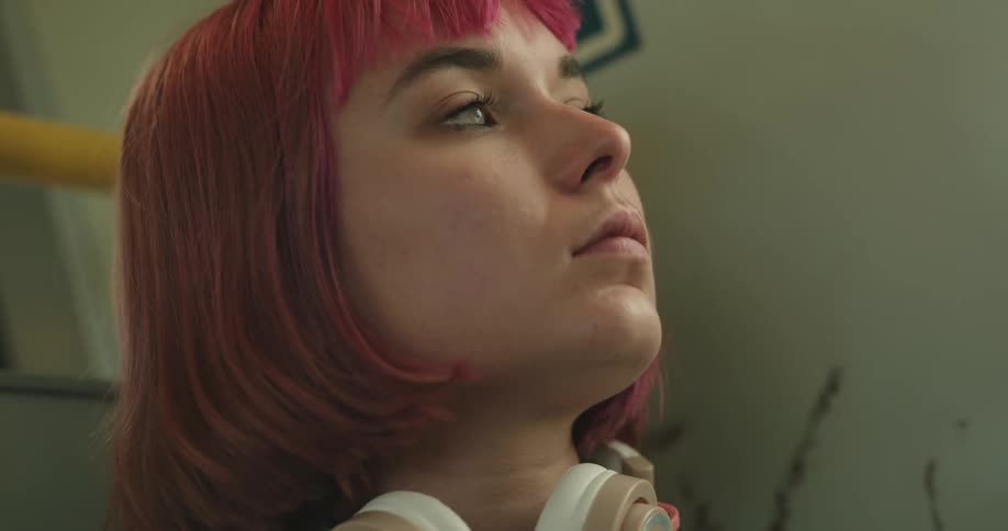 A woman is sitting and wearing headphones