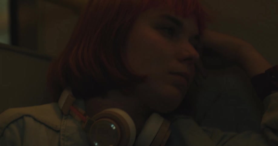 A woman sleeps on a train with headphones around her neck