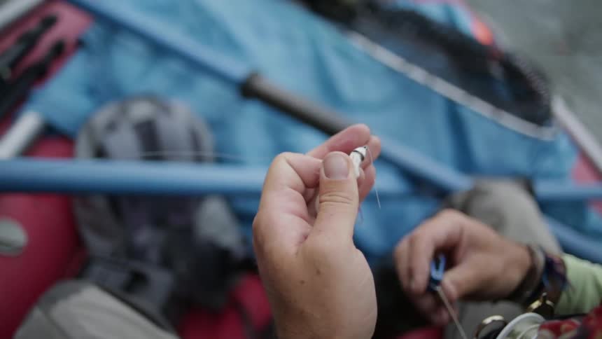 A man ties a piece of fishing line