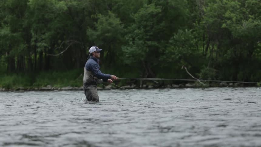 A man is fly fishing in a lake