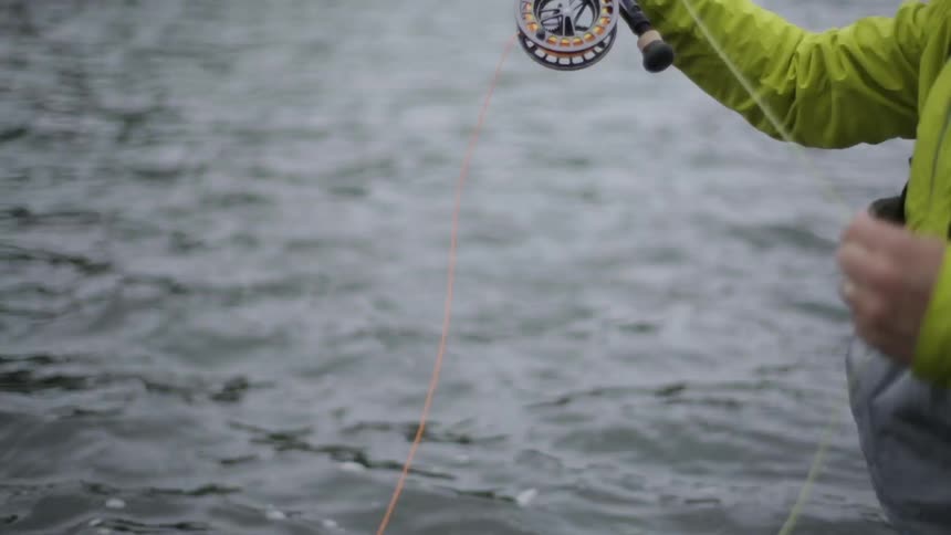 A fisherman casts his line in a river