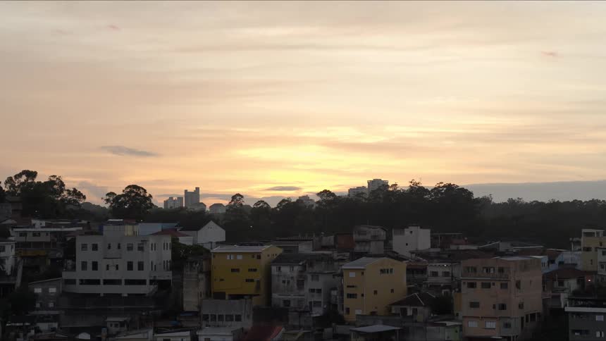 Simple houses in slums, with tree-covered hills and buildings, sky and clouds in the background