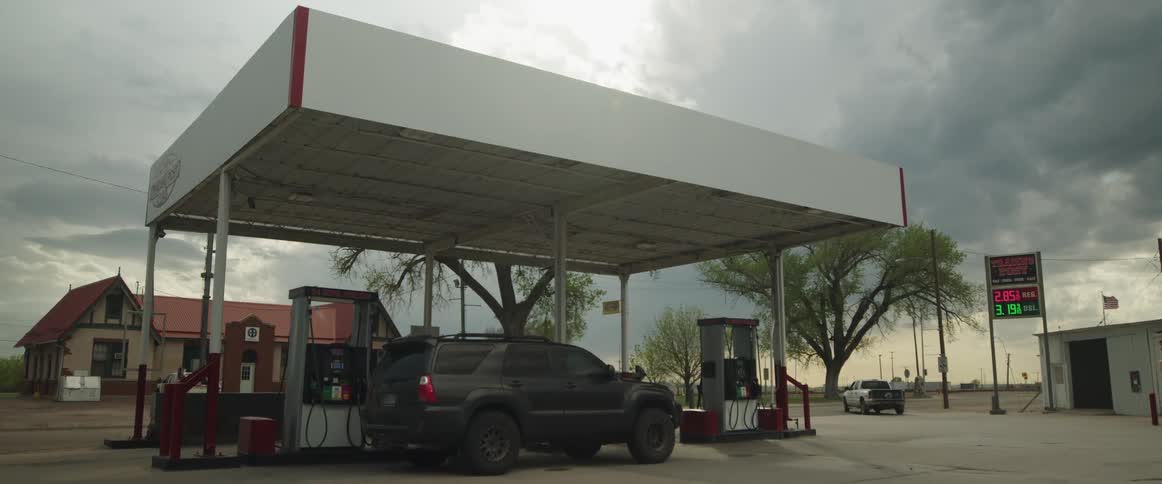 Car parked in front of the pump on a gas station in a small town