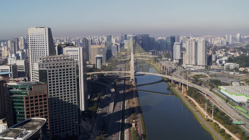Cable-stayed bridge spanning a river in a metropolis during the day