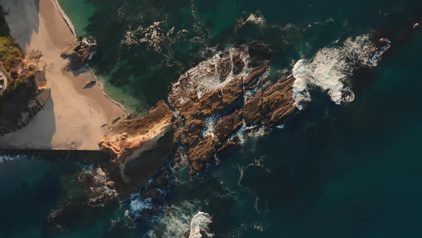 Strong waves crashing into rocky beach