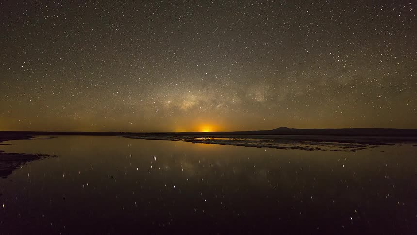 Timelapse of lake with starry night sky and the moonset reflection